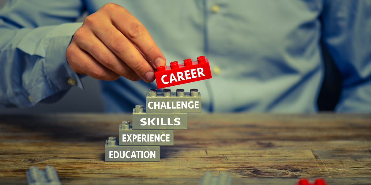 Close-up of a person stacking Lego blocks, with the top one saying "Career" on the side
