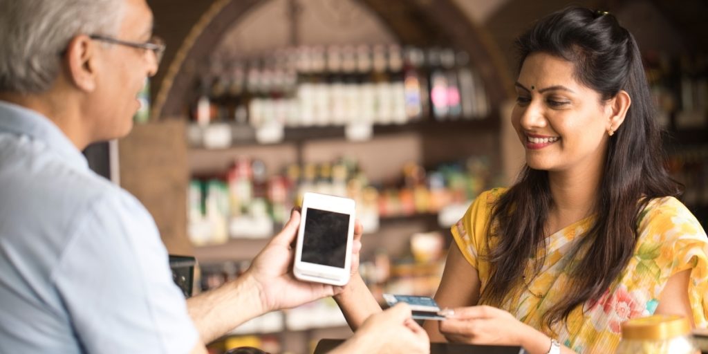 Indian woman and man completing a purchase with a credit card
