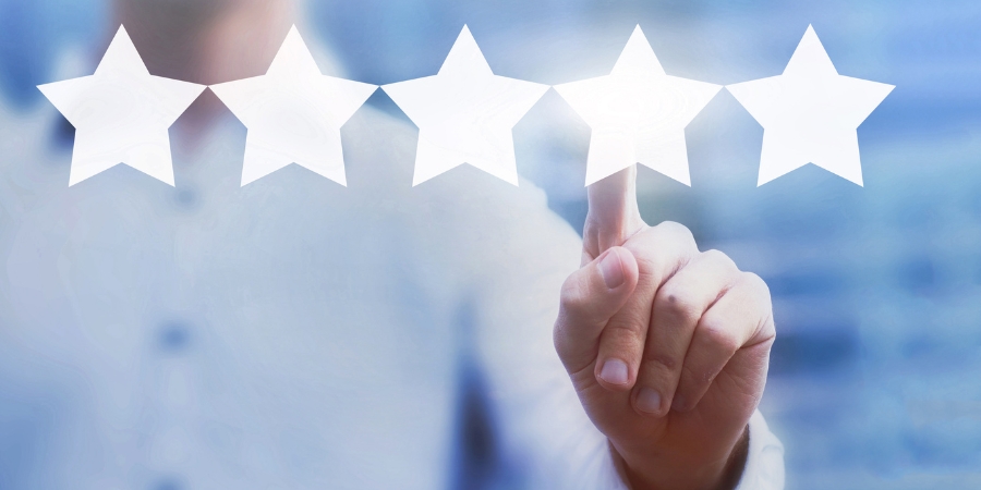Person's finger touching one of five stars