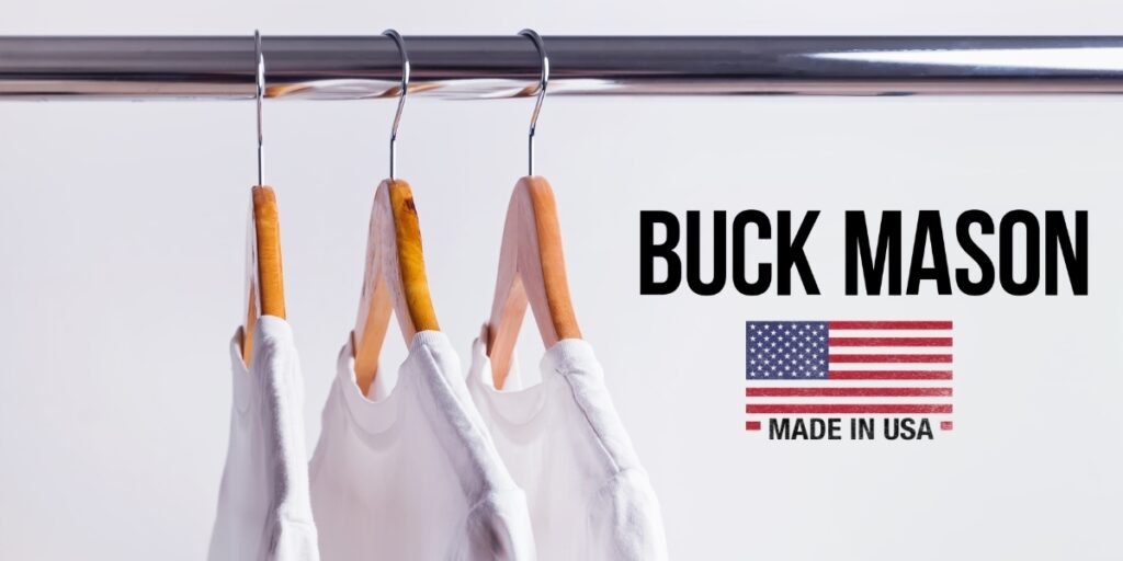 Close-up of three hanging T-shirts next to the Buck Mason logo