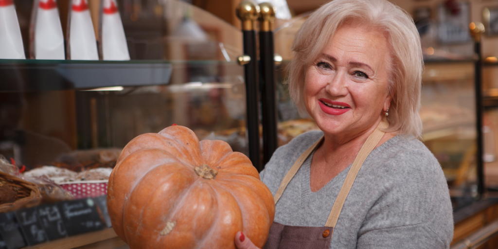 Woman holding a pumpkin in a grocery store